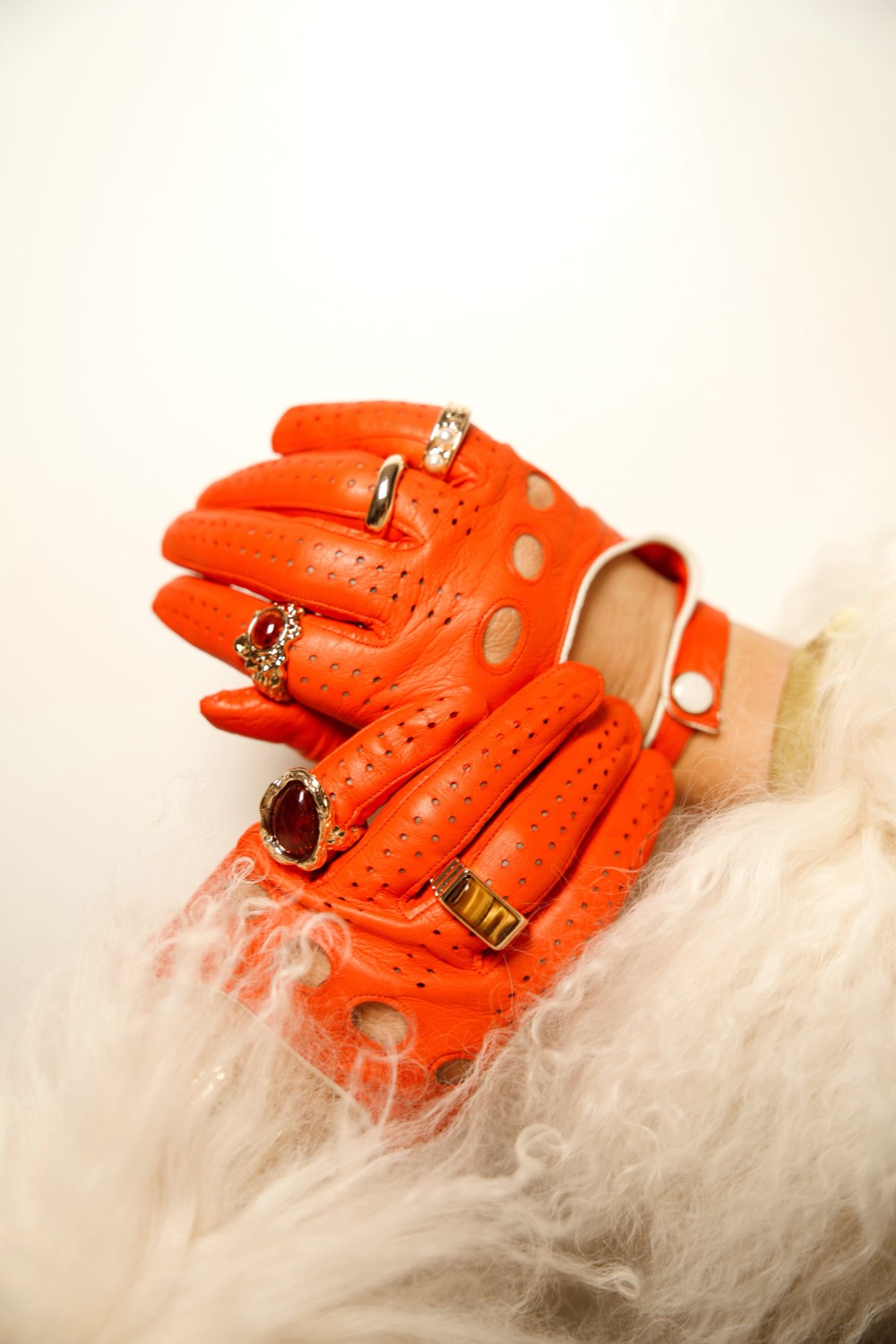 Orange gloves resting on white fur