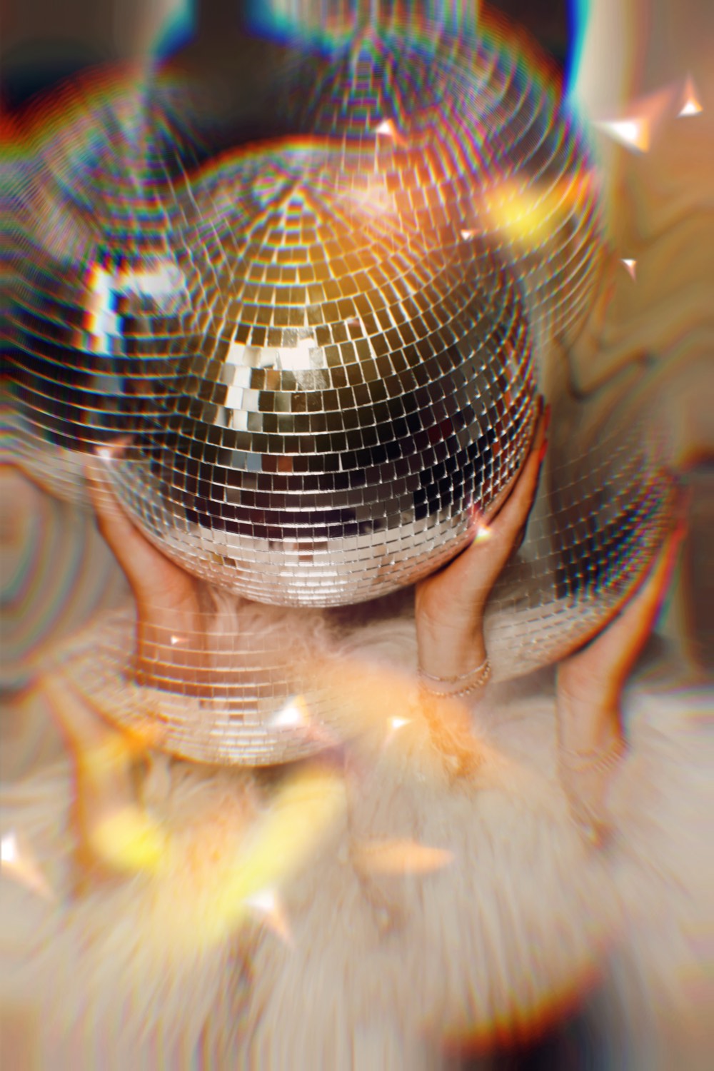 A mirrorball held up in warm light