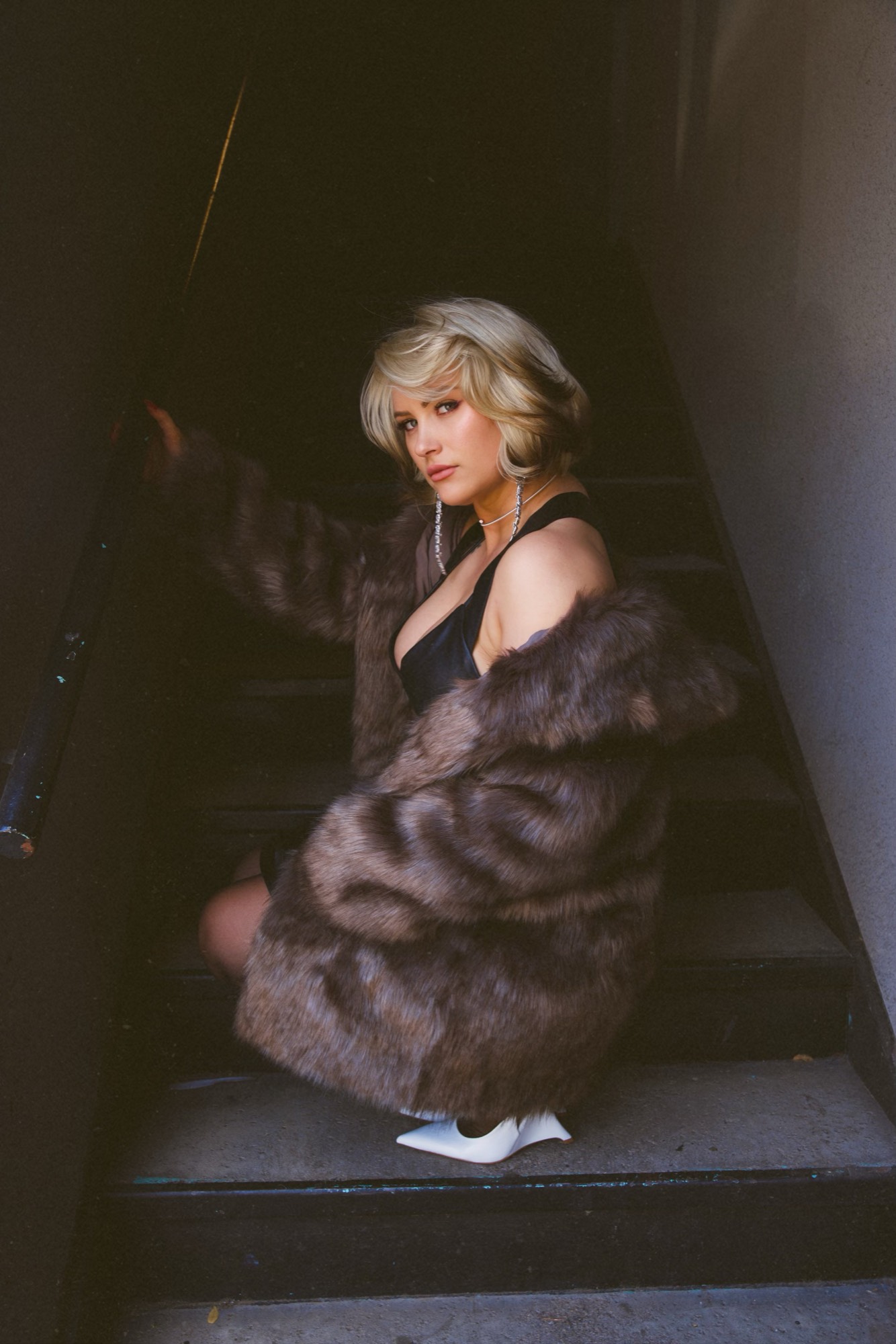 Corey Earl in a fur coat on the studio stairwell
