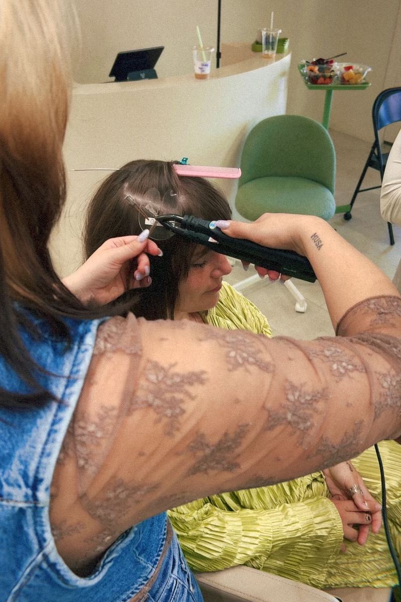 Corey Earl sectioning and flat-ironing a client at the studio